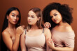 © iordani - young pretty asian, caucasian, afro woman posing cheerful together on brown background, lifestyle diverse nationality people concept