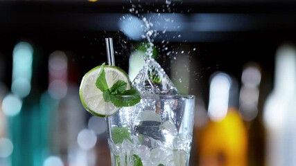 Fototapete - Super slow motion of falling ice cube into mojito drink, camera movement. Filmed on high speed cinema camera, 1000 fps.