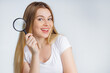 © Ivan - Happy smiling female holding magnifying glass, isolated on white background