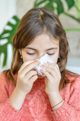 Wall Mural - The child wipes a runny nose with a napkin. Selective focus.