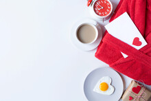 
Terry Red Bath Robe, Heart-shaped Scrambled Eggs, A Gift, A Coffee Mug, An Alarm Clock And A Letter Envelope Are On A White Background. Valentine's Day Breakfast Theme. Free Space For Text.