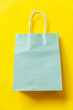 Simply minimal design shopping bag isolated on yellow background. Online or mall shopping shopaholic concept. Black friday Christmas season sale. Flat lay top view copy space, mock up