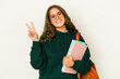 © Asier - Young caucasian student woman isolated joyful and carefree showing a peace symbol with fingers.