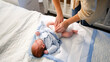 © Kyrylo Ryzhov - Top view of young caring mother changing messy diapers of her newborn baby boy at night. Concept of hygiene, health of mother and child