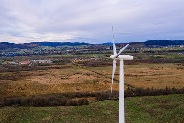 Silhouette of a wind turbine on a mountain at sunset, a windmill in the Ukrainian Carpathians, a windmill close up, top view.