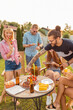 © Impact Photography - Group of young friends having a backyard barbecue party