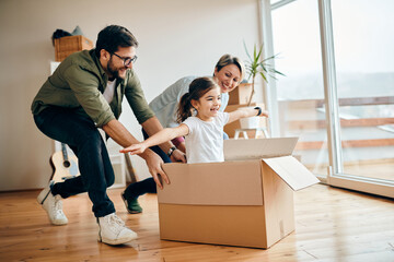 happy daughter having fun with her parents while relocating in new apartment.