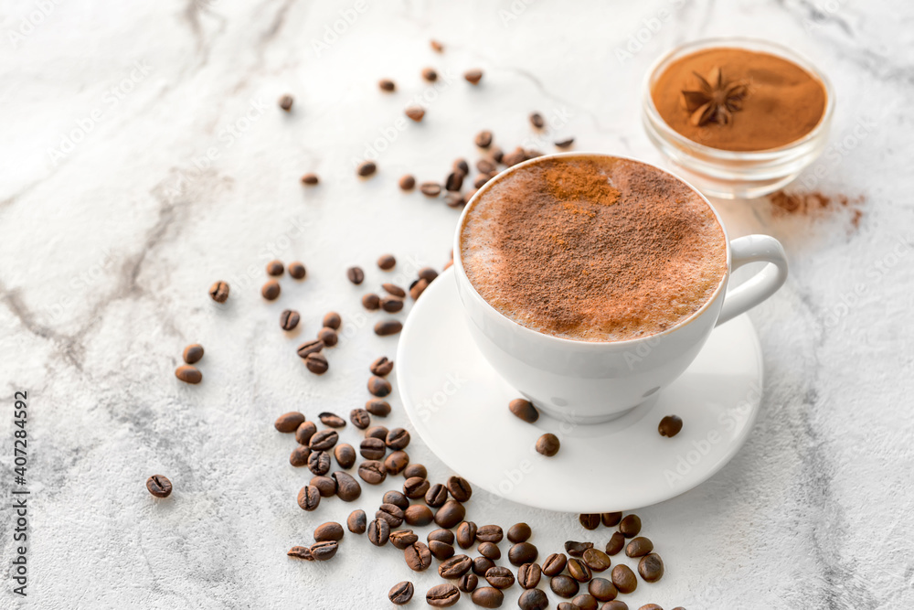 Tasty coffee with cinnamon in cup on light background