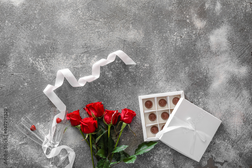 Composition with flowers and candies for Valentine's Day on grey background