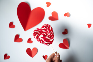 Wall Mural - Valentine's Day background. red hearts and lollipop on white background. Valentines day concept. Flat lay, top view, copy space