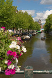 Fototapeta Londyn - canal in amsterdam with flowerws and boats in summer