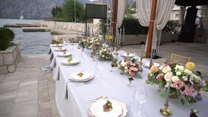 Wall Mural - A table at a wedding banquet, decorated with flowers, candlesticks and young pomegranates on the pier in the Bay of Kotor