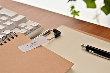 Leinwandbilder - A sticky note labeled LPO is taped to the edge of a notebook on the desk.That's an acronym for Landing Page Optimization.
