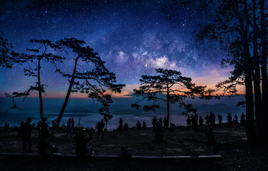 Wall Mural - tourist with milky way galaxy on the mountain viewed from a high angle. image exposure with long gra