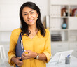 Cheerful business woman in light office holding clipboard with papers document write notes