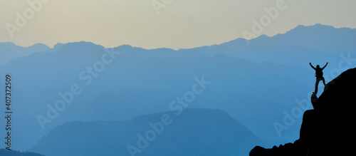 Fototapeta na szkło silhouette of a person on a mountain top
