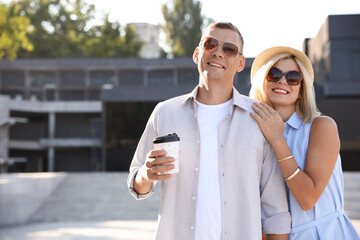 Sticker - Happy couple with drink walking along city street on summer day