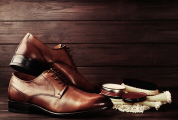 Shoe care accessories and footwear on wooden background