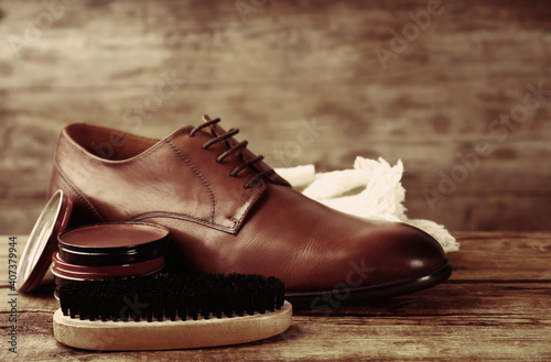 Obraz Dibond Footwear care accessories and shoe on wooden background