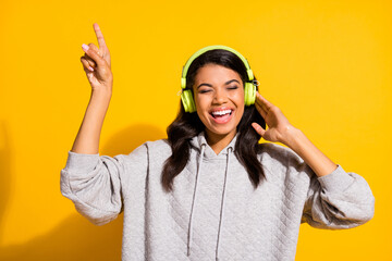 Sticker - Photo of funky attractive afro american woman point finger wear headset listen music rest isolated on yellow color background