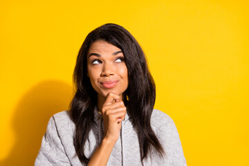 Poster - Photo of dreamy shiny dark skin girl dressed grey sweatshirt arm chin looking empty space isolated yellow color background