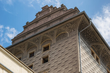 architectural details of an old high-rise building against a blue sky. close-up. wall and roof decor. beige 0-brown shades. summer sunny day in Prague (Czech Republic)