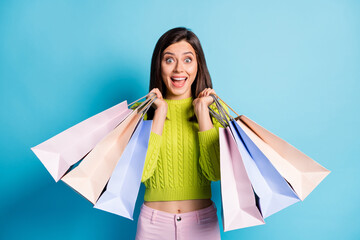 Poster - Photo portrait of shocked girl holding shopping bags isolated on pastel blue colored background