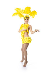 Dancing. Beautiful young woman in carnival, stylish masquerade costume with feathers dancing on white studio background. Concept of holidays celebration, festive time, dance, party, having fun