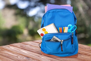 Sticker - Classic school backpack with colorful school supplies and books on desk.