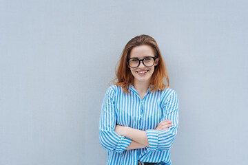 Wall Mural - young woman with glasses looks positively into the camera