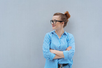 Wall Mural - young woman with glasses and crossed arms looks to the side