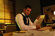© New Africa - Old fashioned detective reading newspaper at table in office