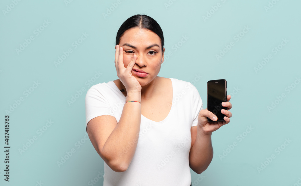 hispanic woman feeling bored, frustrated and sleepy after a tiresome, dull and tedious task, holding face with hand - obrazy, fototapety, plakaty 
