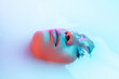 Leinwandbild Motiv Delighted. Beautiful female face in the milk bath with soft glowing in blue-pink neon light. Copyspace for advertising. Modern neoned colors, foam. Beauty, fashion, style, skincare concept. Attractive