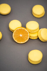 Wall Mural - high angle view of delicious yellow macarons near half of juicy lemon on grey background