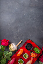 Valentine Day Festive Dinner Idea. Menu, Invitation Background For Valentine Day Sushi Roll Set, With Heart Shaped Decor And Rose Flowers Bouquet. Top View With Copy Space For Text