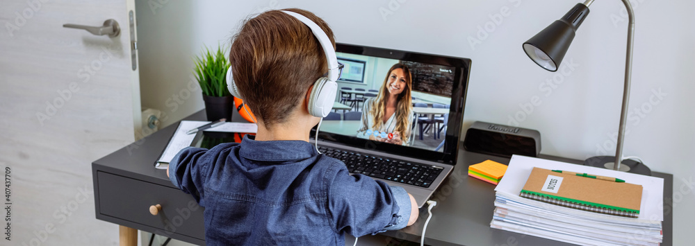 Unrecognizable boy with headphones receiving class at home with laptop from his bedroom. Home schooling concept - obrazy, fototapety, plakaty 