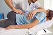 © Studio Romantic - Professional chiropractor or physiotherapist helps to heal a young woman's back.