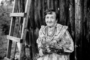 Portrait of old woman in the russian village. Black and white photo.