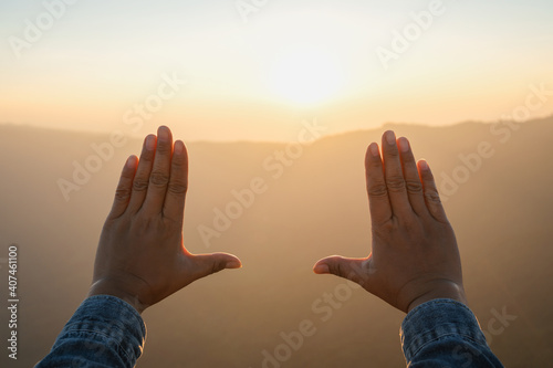 Obraz Dibond woman hand framing looking view sunrise on mountain