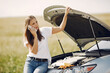 © prostooleh - Woman by the car. Lady in a white t-shirt. Broken car. Woman need to help.