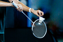 Holding A White Badminton Racket Ready To Hit The Ball