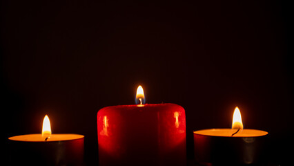 three candles on a black background. close up