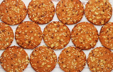 Wall Mural - Freshly baked homemade vegan oatmeal cookies with cereals - flax seed, sesame and sunflower. Useful snack. The concept of healthy eating. Culinary background top view
