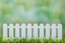 Spring Grass And Wooden Fence With Green Defocused Background