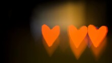 Four Orange Hearts Shaped Lights On The Dark During The Valentines Day