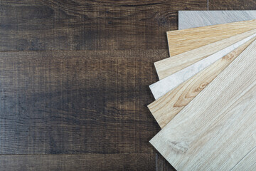 Vinyl and linoleum samples on a wooden background. Vinyl for flooring with wood grain texture and pattern.