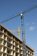 © Константин Сапрыкин - Construction equipment in construction new house background. .Construction cranes on the construction site. Crane and building construction site against blue sky.