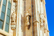 Facade of Milan Cathedral Duomo di Milano with Gothic spires and white marble statues. Top tourist attraction on piazza in Milan, Lombardia, Italy. Wide angle view of old Gothic architecture and art.