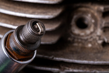 Spark plug on the background of the internal combustion engine. Minor repair work on the internal combustion engine.